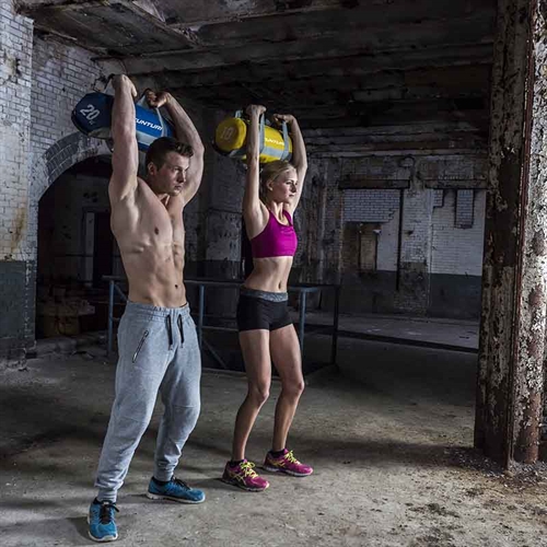 Mand og dame træner med Tunturi PowerBag - 15 kg