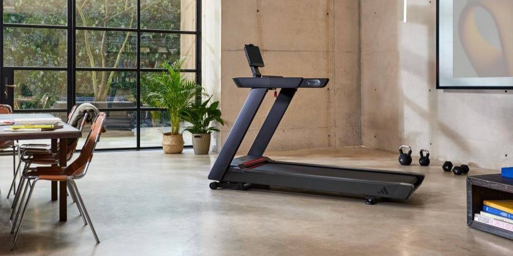 Adidas tredemølle i moderne stue med store vinduer