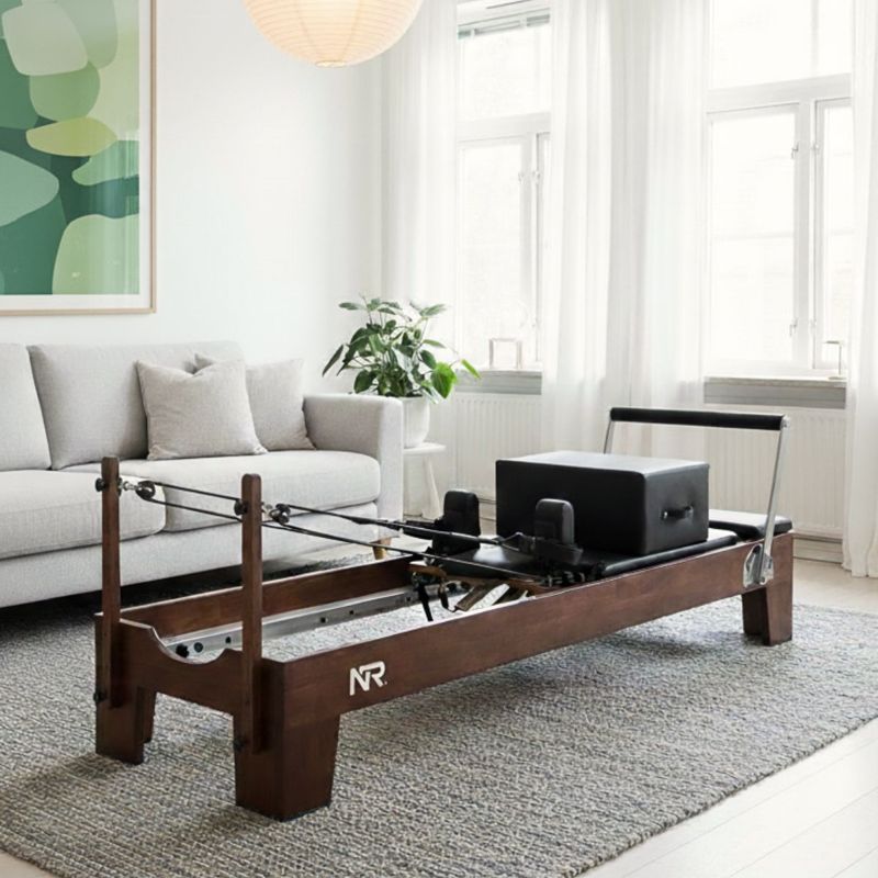 Reformer pilates maskin oppstilt i stuen til hjemmetrening